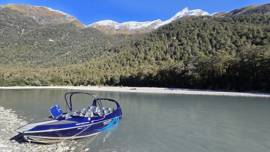 Dart River jetboat parked in stunning scenery and snow-capped mountains